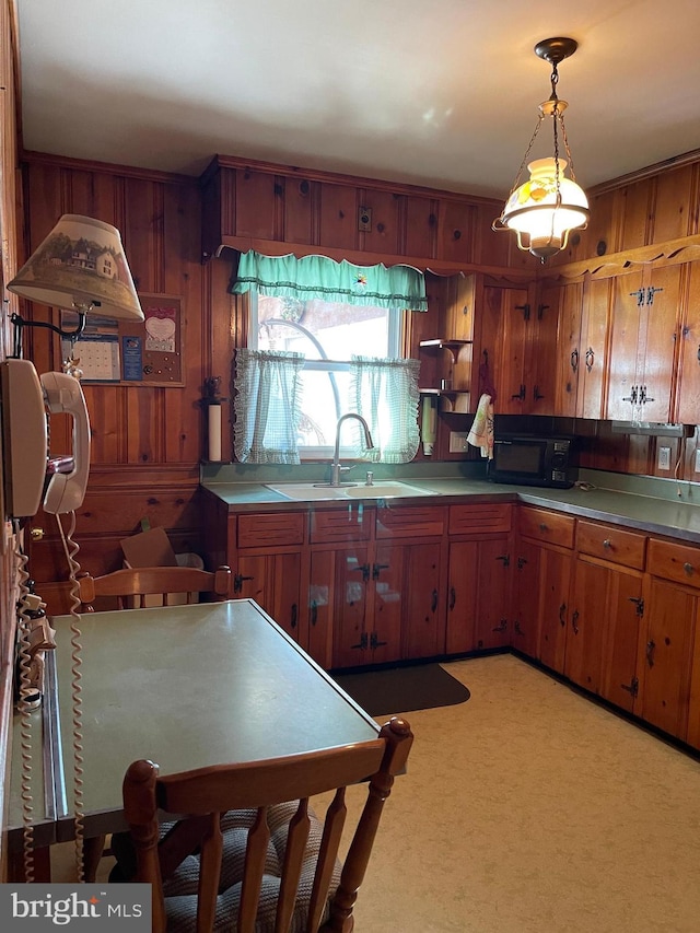 kitchen with sink, wood walls, and decorative light fixtures