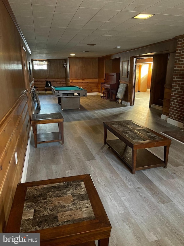 recreation room with pool table, wooden walls, and light hardwood / wood-style floors