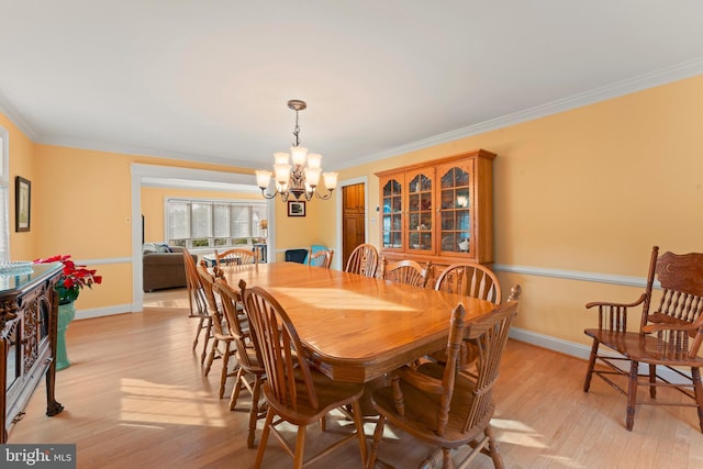 dining room featuring crown molding, light hardwood / wood-style floors, and a chandelier