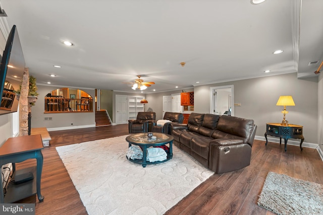 living room with ornamental molding, dark hardwood / wood-style floors, and ceiling fan