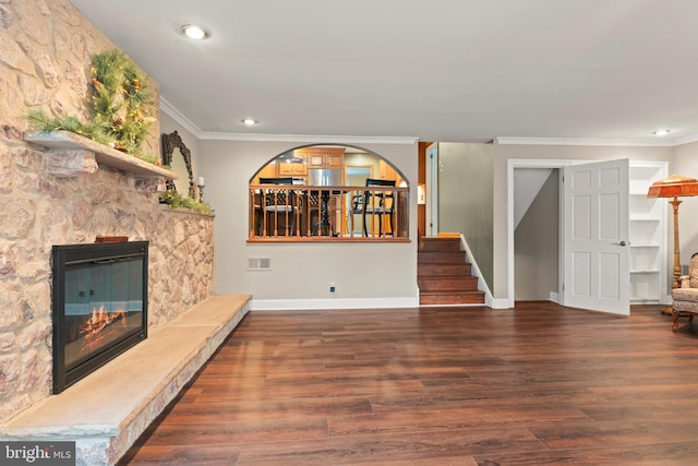 unfurnished living room with dark hardwood / wood-style flooring, a fireplace, and ornamental molding