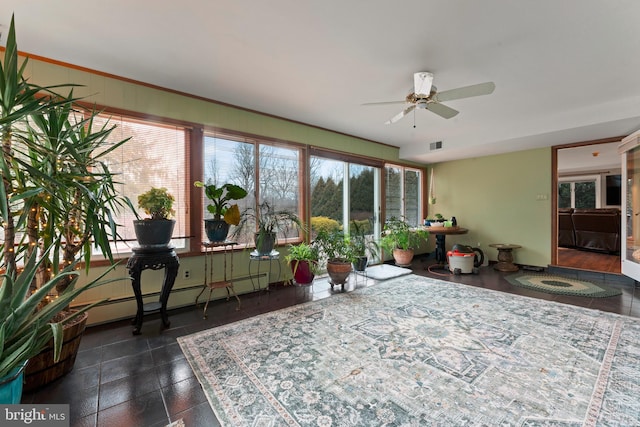 sunroom with baseboard heating and ceiling fan