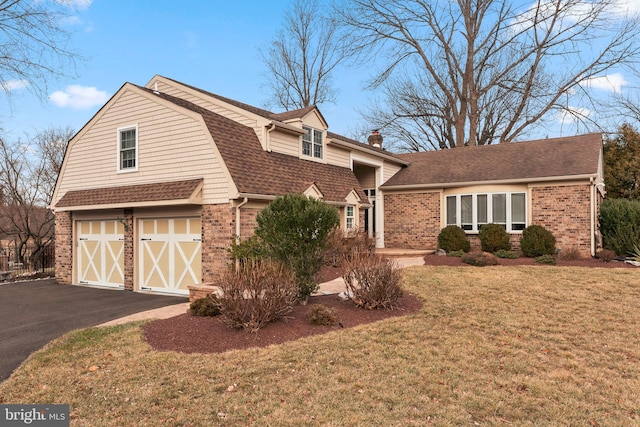 view of front of home with a garage and a front lawn