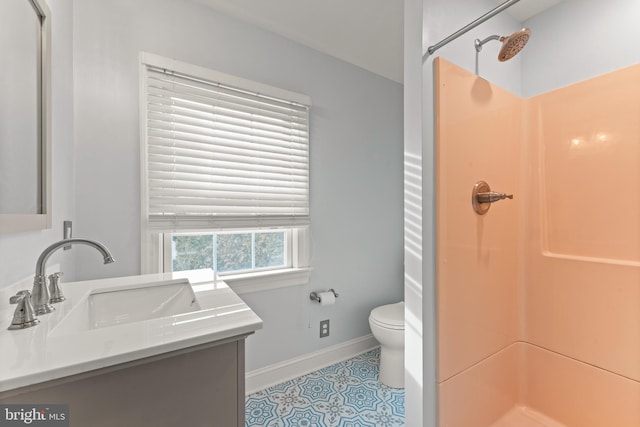 bathroom with vanity, tile patterned flooring, toilet, and walk in shower