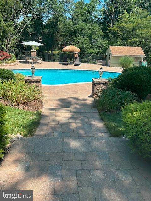 view of pool with an outbuilding and a patio area