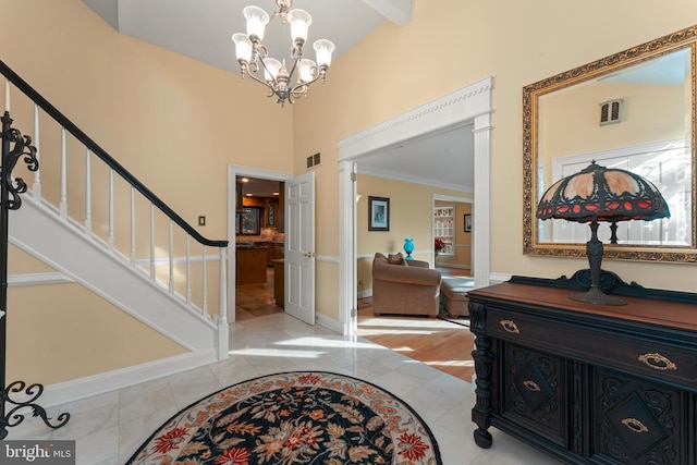 entrance foyer featuring a high ceiling, crown molding, and a notable chandelier