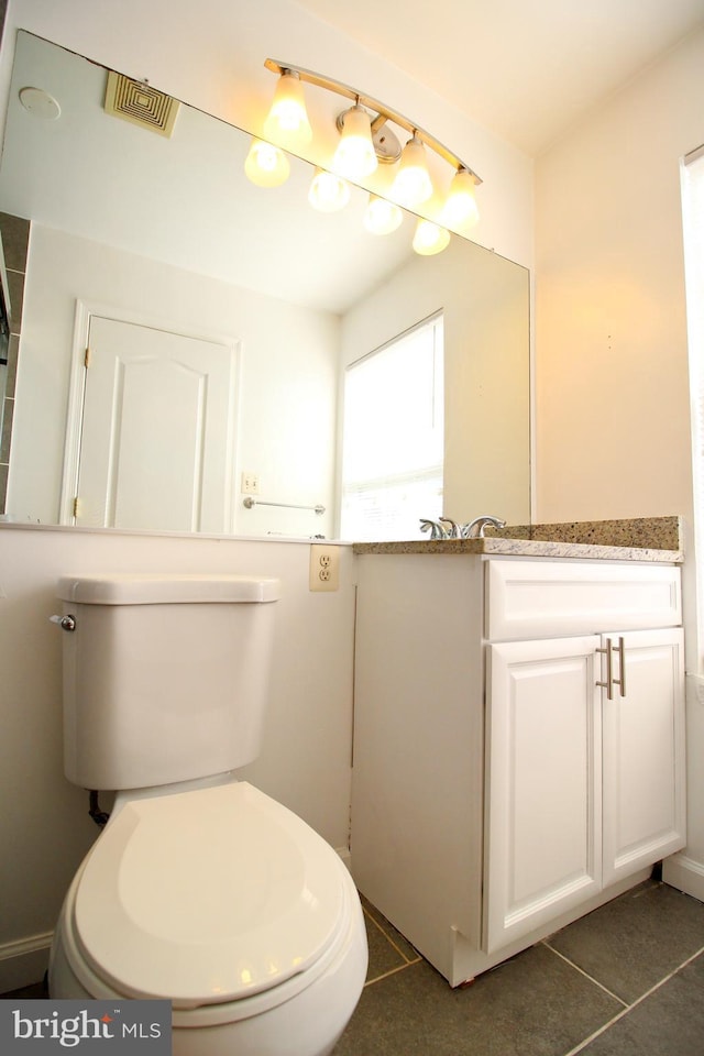 bathroom featuring vanity, tile patterned floors, and toilet