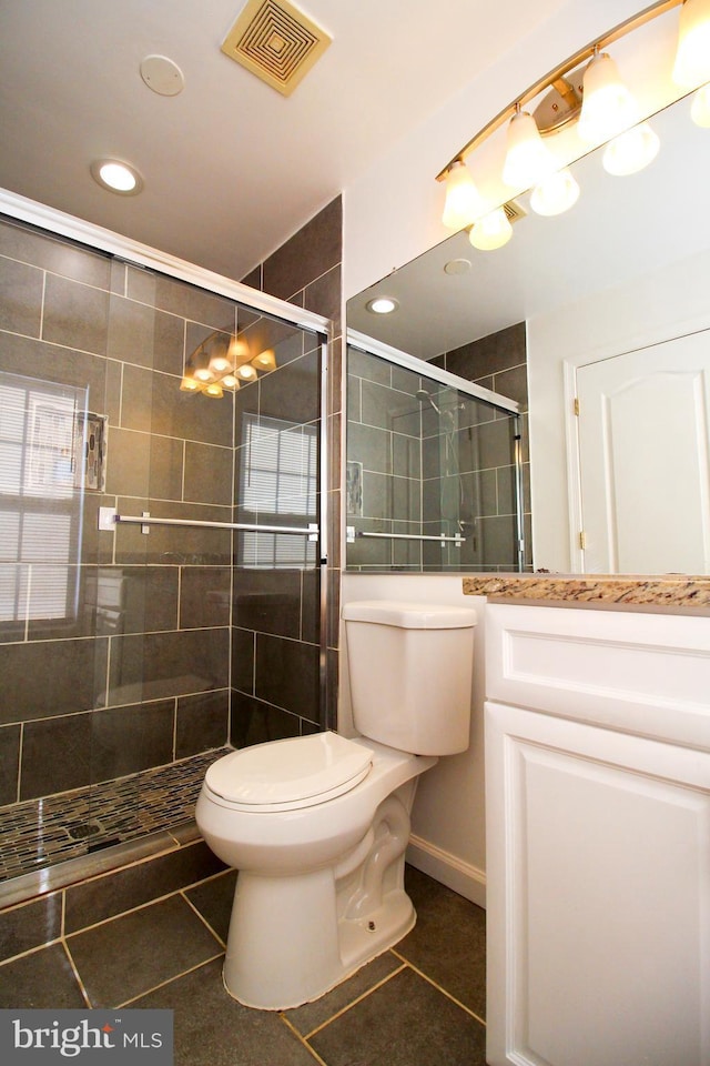 bathroom featuring a shower with shower door, tile patterned floors, and toilet