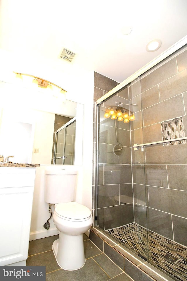 bathroom with vanity, toilet, an enclosed shower, and tile patterned flooring