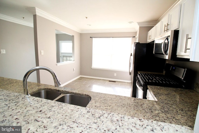 kitchen featuring sink, white cabinetry, light stone counters, ornamental molding, and appliances with stainless steel finishes