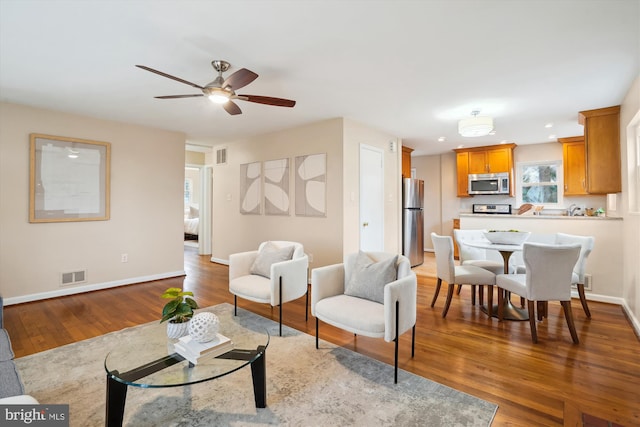 living area featuring baseboards, visible vents, and light wood-style floors