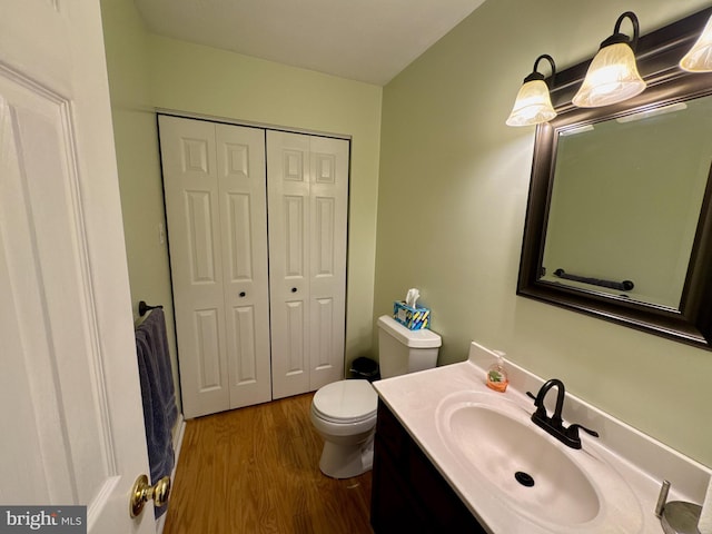 bathroom featuring vanity, wood-type flooring, and toilet