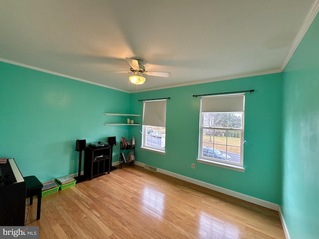 misc room featuring crown molding, ceiling fan, and light wood-type flooring