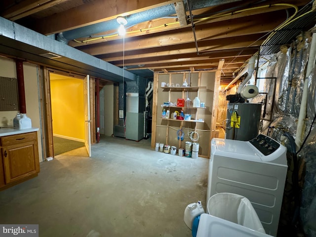 basement featuring water heater, heating unit, and washing machine and clothes dryer