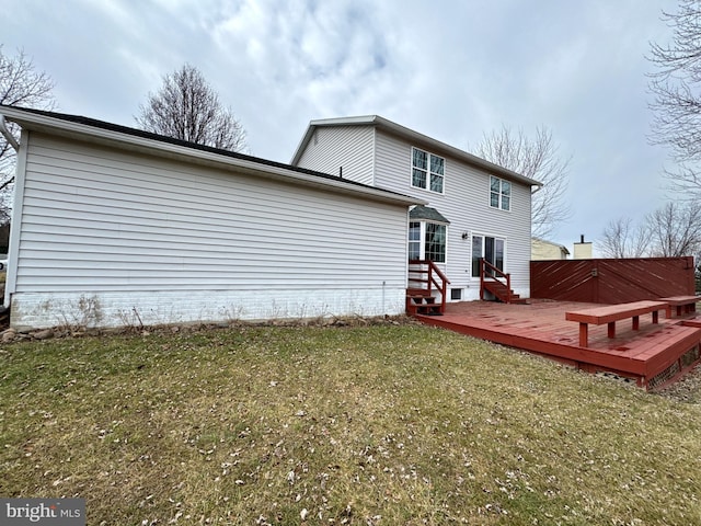 back of property featuring a deck and a lawn