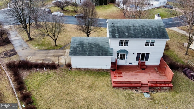 rear view of property featuring a wooden deck and a yard