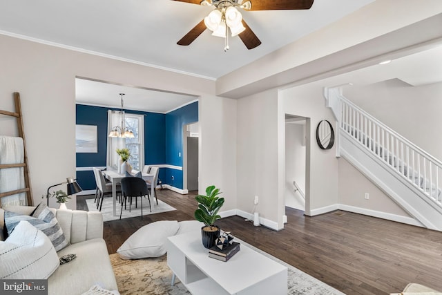 living area featuring stairway, baseboards, crown molding, and wood finished floors