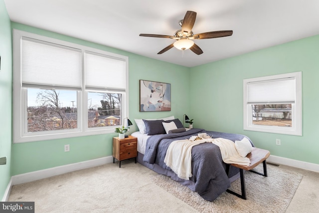 bedroom featuring light carpet, visible vents, baseboards, and a ceiling fan