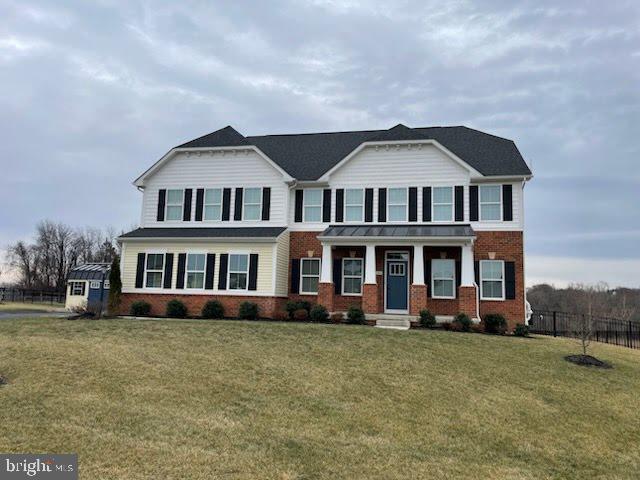 view of front of home featuring brick siding and a front yard