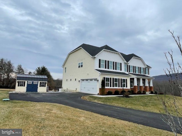 view of property featuring an outbuilding, a porch, a garage, and a front lawn