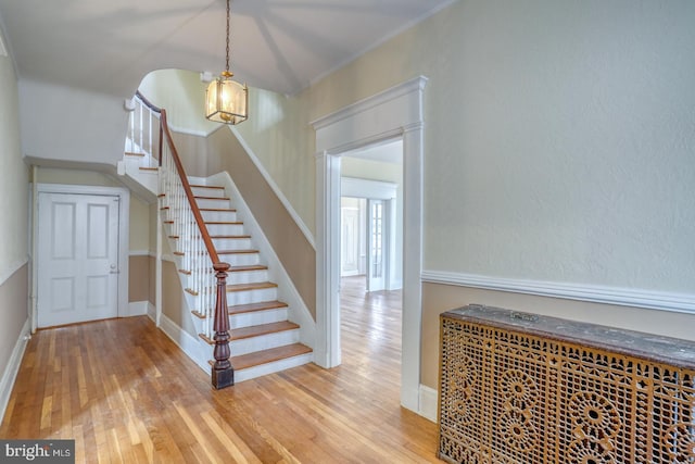 staircase featuring crown molding and wood-type flooring