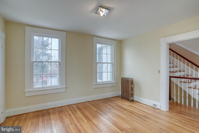 unfurnished room with radiator and light hardwood / wood-style flooring