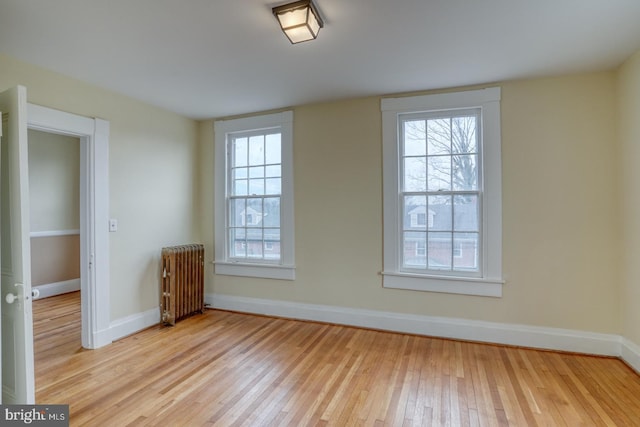 empty room with radiator heating unit and light wood-type flooring