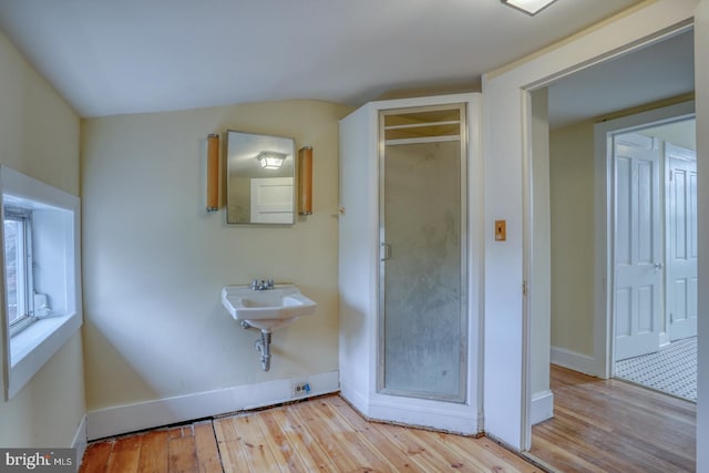 bathroom featuring hardwood / wood-style flooring and lofted ceiling