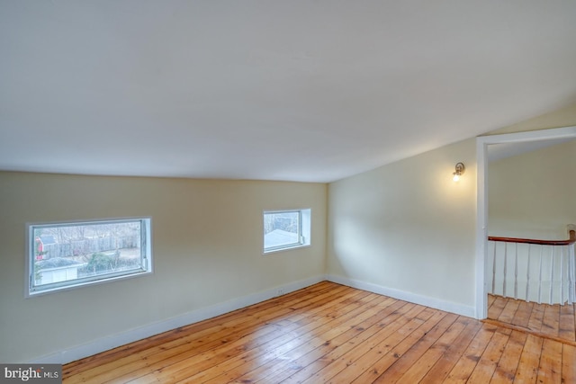 empty room featuring lofted ceiling and light hardwood / wood-style flooring