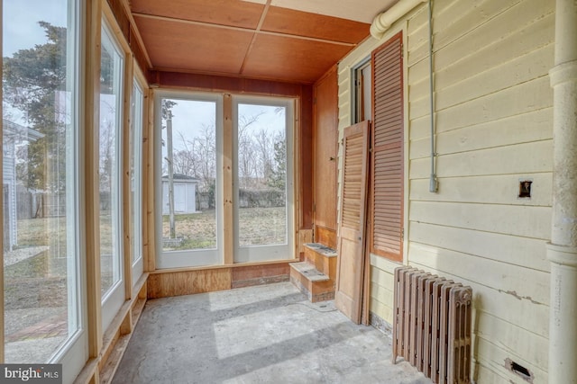 unfurnished sunroom with a wealth of natural light and radiator heating unit