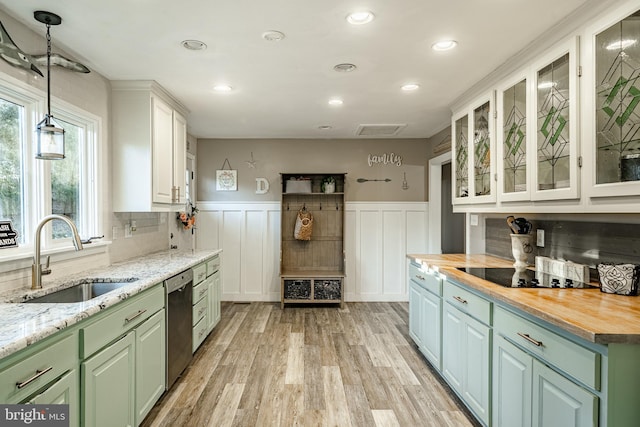 kitchen featuring sink, wooden counters, white cabinetry, black electric cooktop, and stainless steel dishwasher