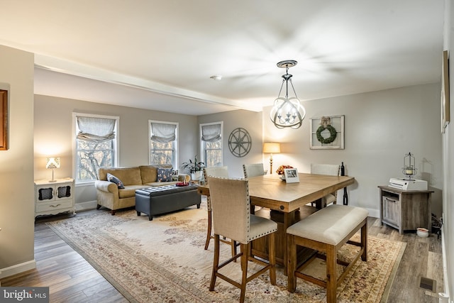 dining area featuring hardwood / wood-style flooring and a chandelier