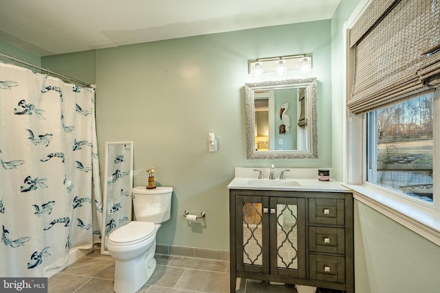 bathroom featuring walk in shower, vanity, toilet, and tile patterned flooring