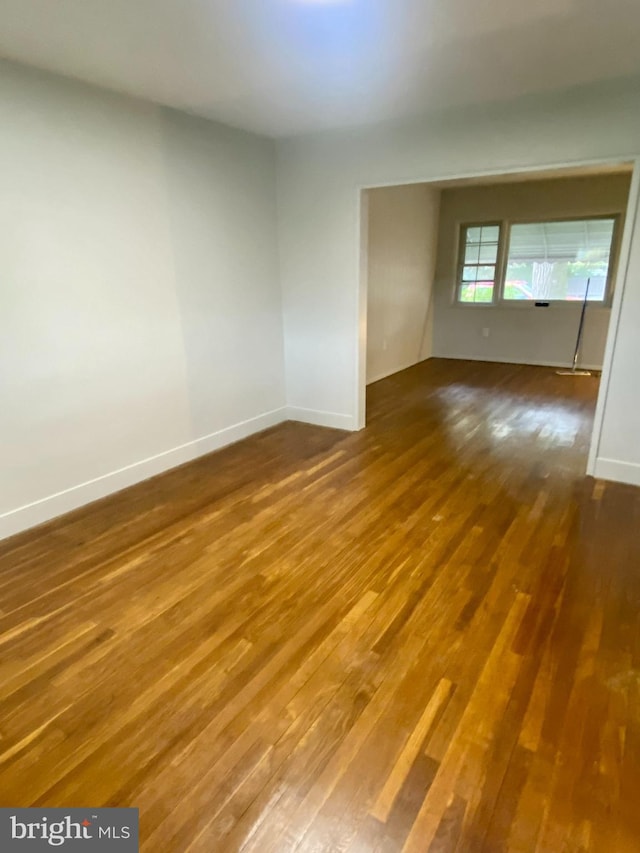 unfurnished room with dark hardwood / wood-style flooring