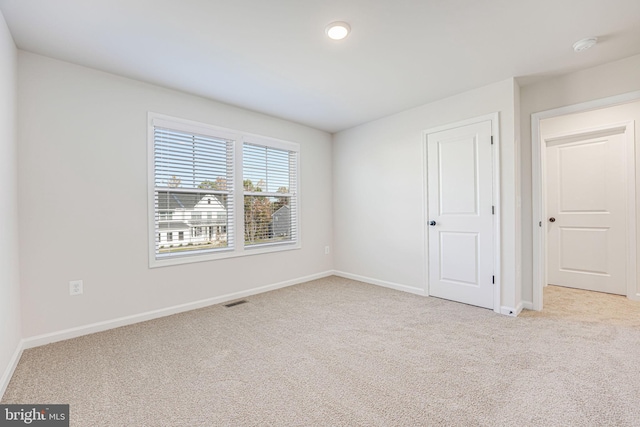 unfurnished room featuring light carpet