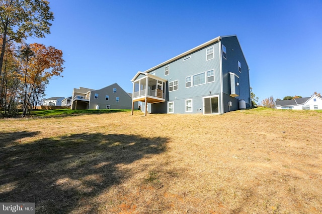 rear view of property with a yard and a sunroom