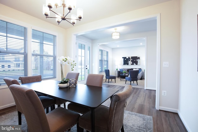 dining area featuring a notable chandelier and dark wood-type flooring