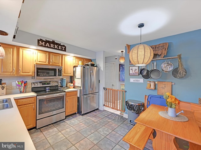 kitchen featuring pendant lighting, stainless steel appliances, and sink