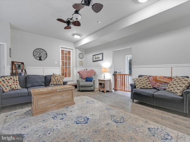 living room featuring wood-type flooring and ceiling fan