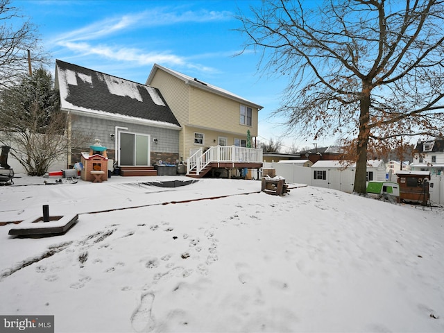 view of snow covered back of property