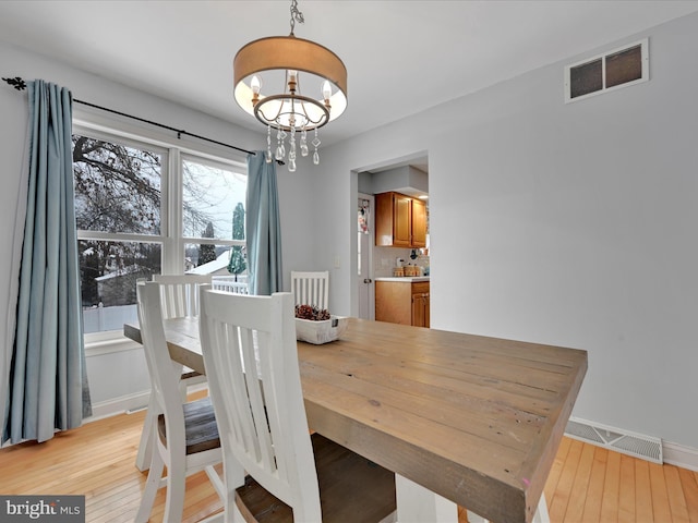 dining space featuring an inviting chandelier and light hardwood / wood-style floors