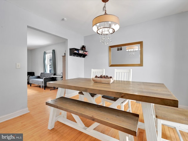 dining space featuring a chandelier and light wood-type flooring