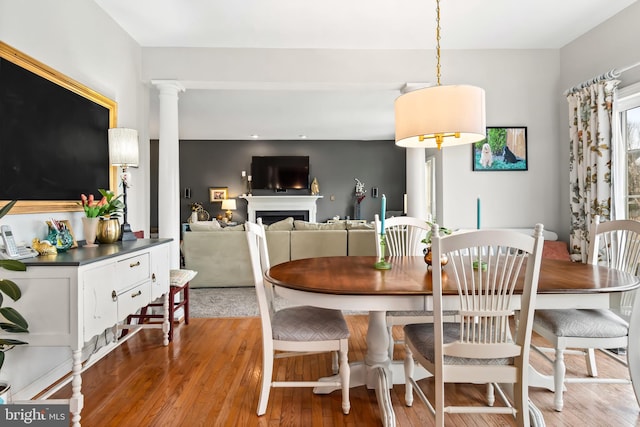 dining room featuring light hardwood / wood-style floors and decorative columns