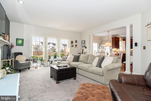 living room with ornate columns and light colored carpet