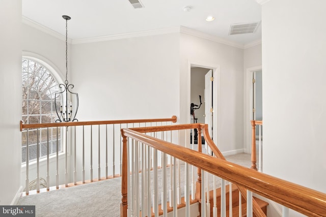 hallway featuring ornamental molding, carpet, and a chandelier