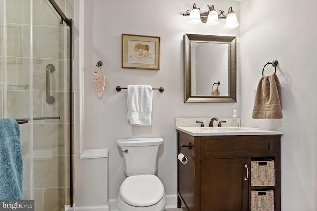 bathroom featuring vanity, toilet, and a shower with shower door