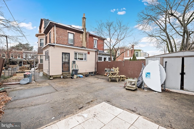 back of property featuring a patio and a storage unit