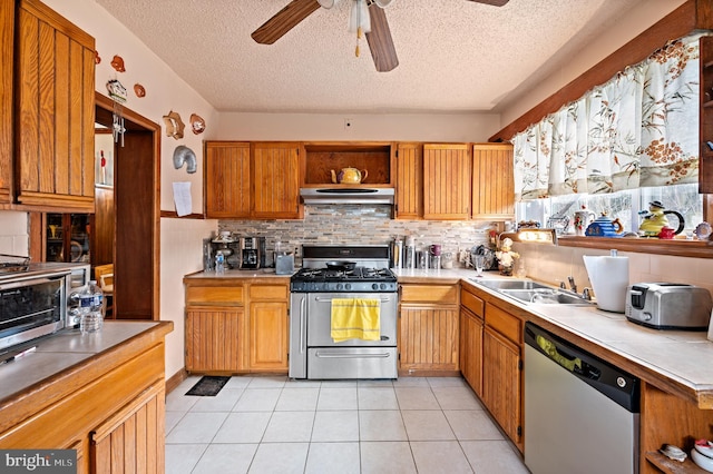 kitchen with sink, light tile patterned floors, ceiling fan, stainless steel appliances, and tasteful backsplash