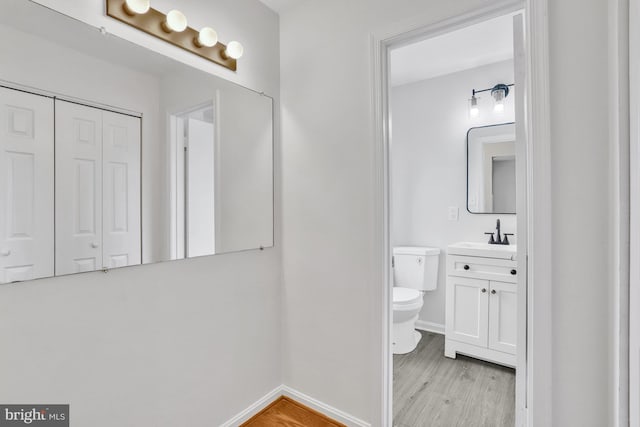 bathroom featuring vanity, hardwood / wood-style floors, and toilet