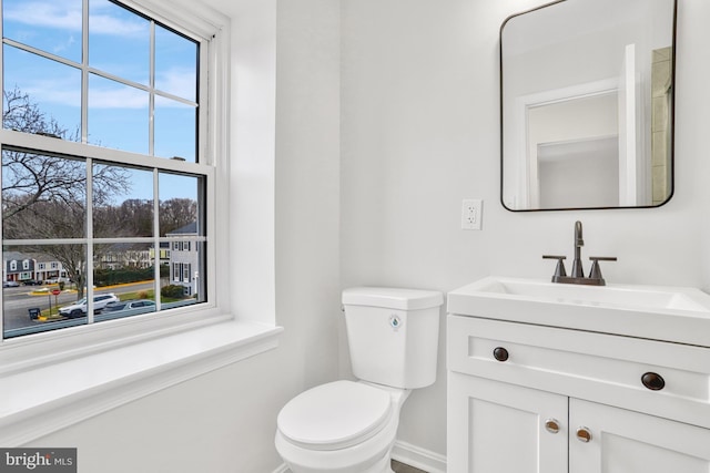 bathroom with vanity, a healthy amount of sunlight, and toilet